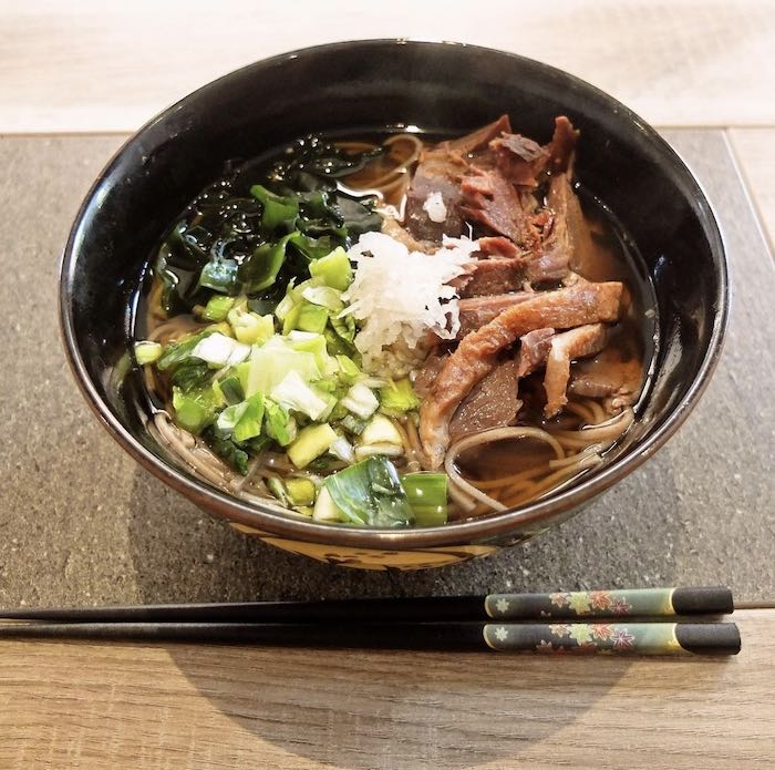 Kamo soba signé Matsumotoya : plat de nouilles de sarrasin et de morceaux de canard plongés dans de la soupe de poisson et d'algues. © Matsumotoya